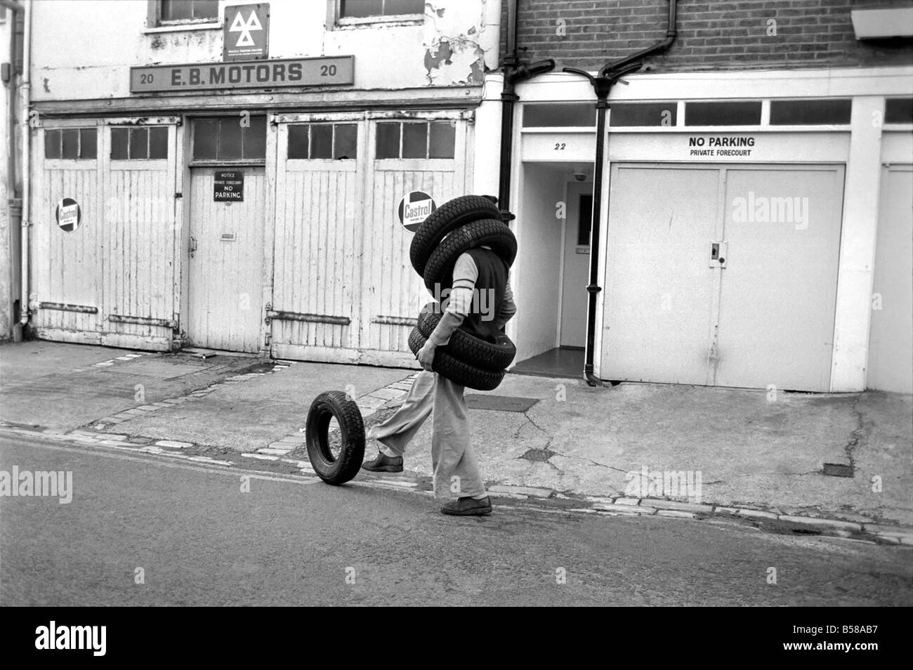 Unusual/Man/Tyres/Humour/Comedy. All Tyred up Brighton Tyre Fitter. February 1975 75-00991-002 Stock Photo