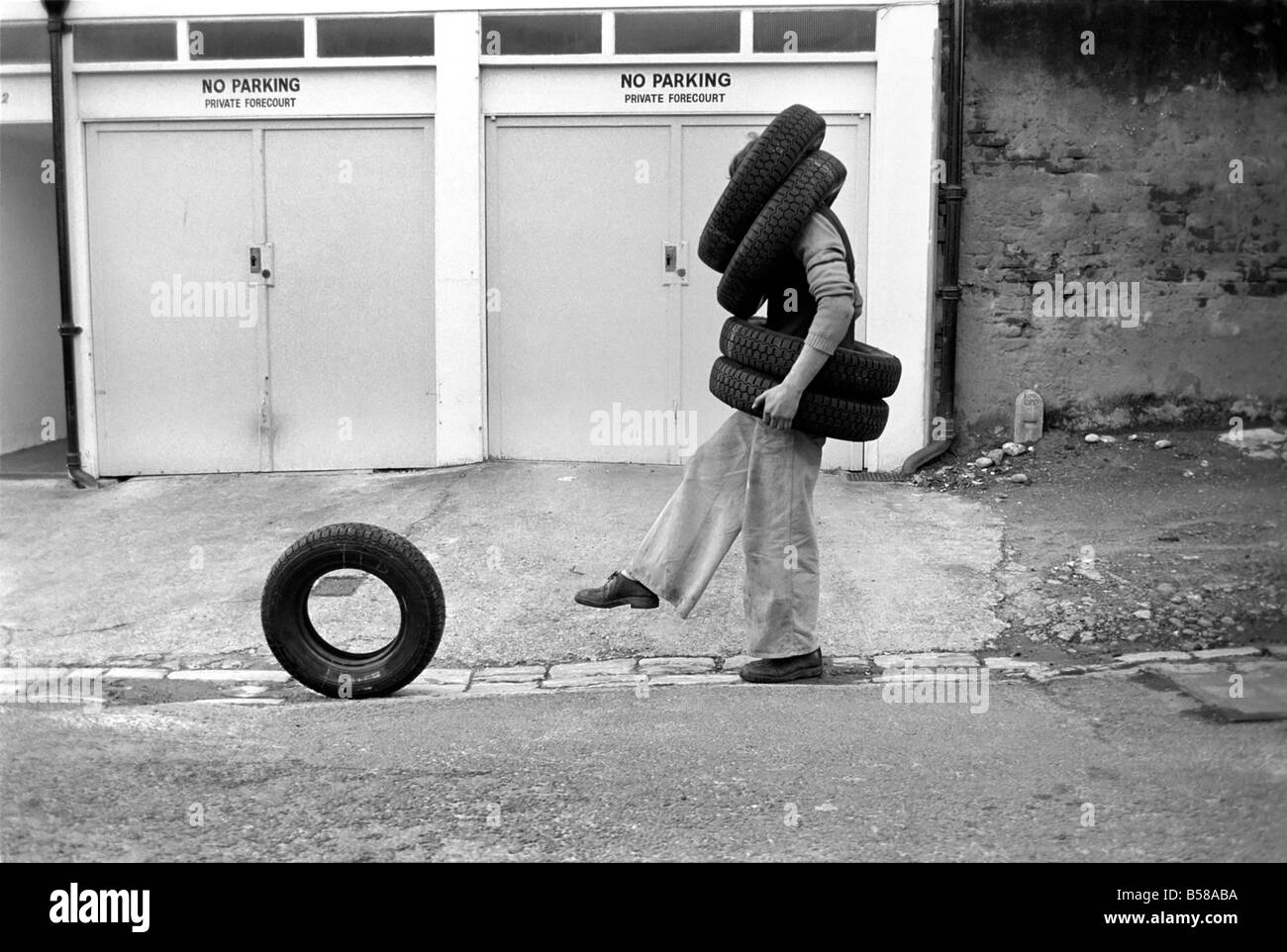 Unusual/Man/Tyres/Humour/Comedy. All Tyred up Brighton Tyre Fitter. February 1975 75-00991-004 Stock Photo