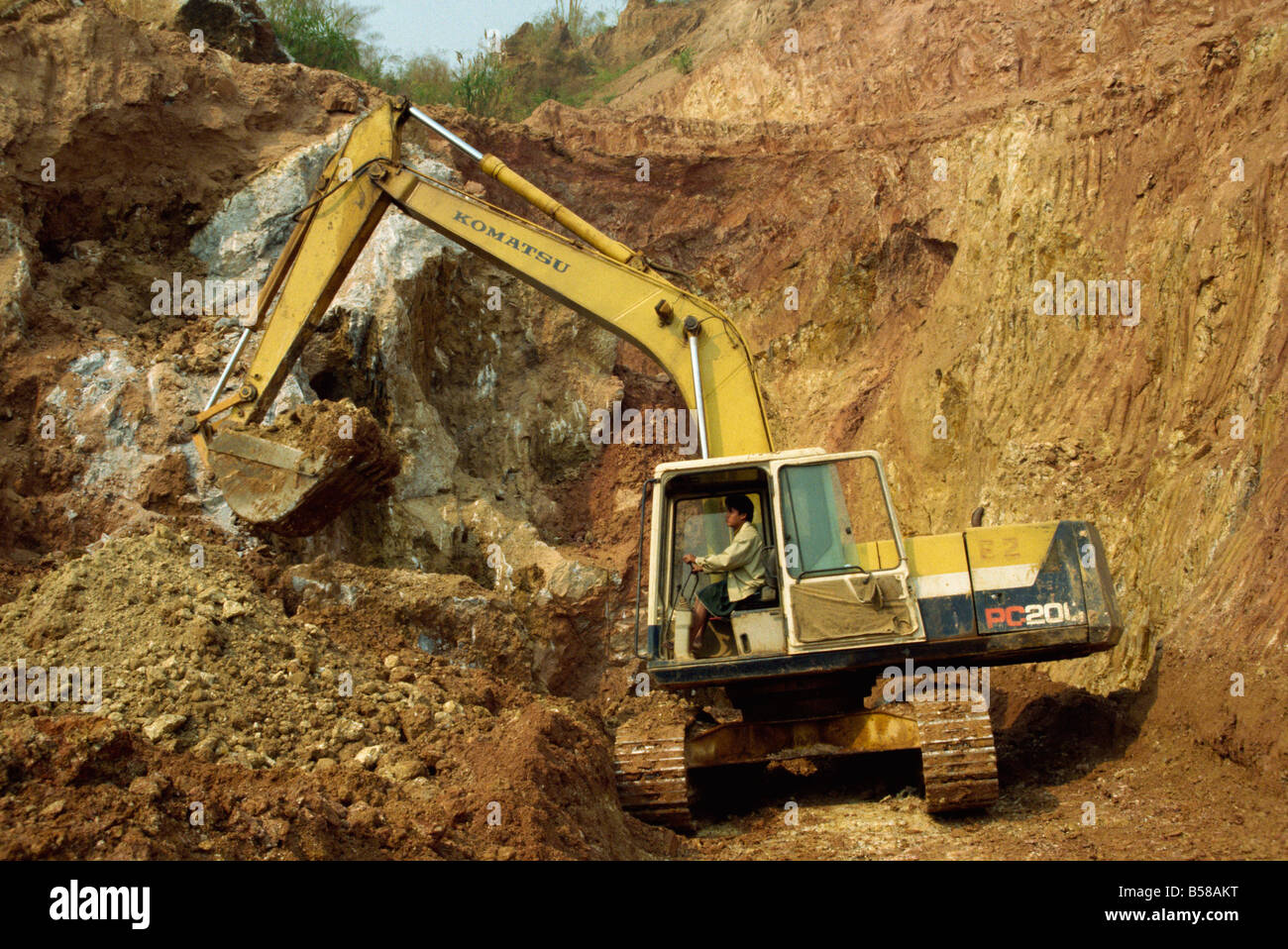 Machine digging gem bearing clay in large open pit mine Mogok ruby mines Mandalay District Myanmar Burma Asia Stock Photo