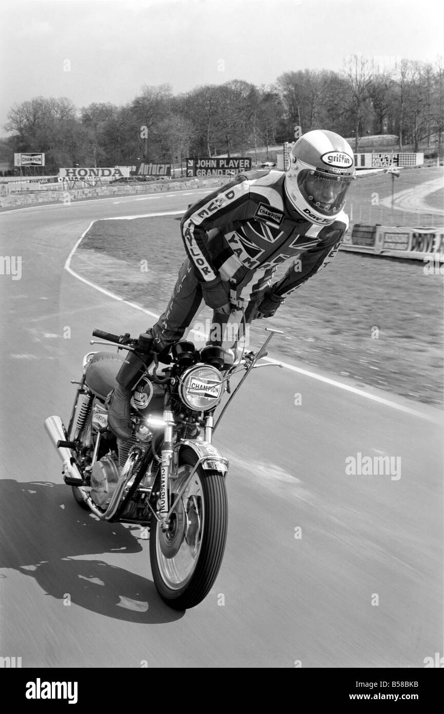 Motorbike stunt: Dave Taylor lives at Barnhurst near Bexley Kent. He is married with three children. Dave is performing a tank stand at 90 M.P.H. along the finishing straight at brands hatch racing circut. This was a slow run. He has done this at over 100 M.P.H. April 1977 77-02121-005 Stock Photo