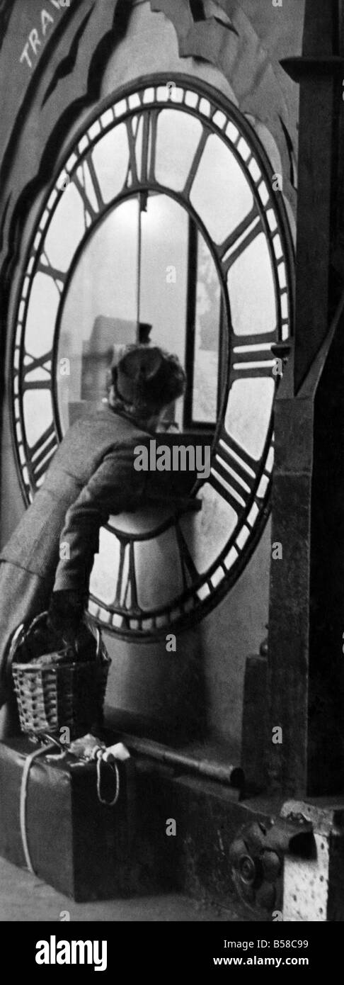 This clock at Liverpool Street Station won't tell you the time - but will answer your questions. Removed from the station roof in the early months of the war for safety reasons, it now serves the public as an enquiry office. During the war it did a useful job as sales counter for savings certificates. P006321 Stock Photo