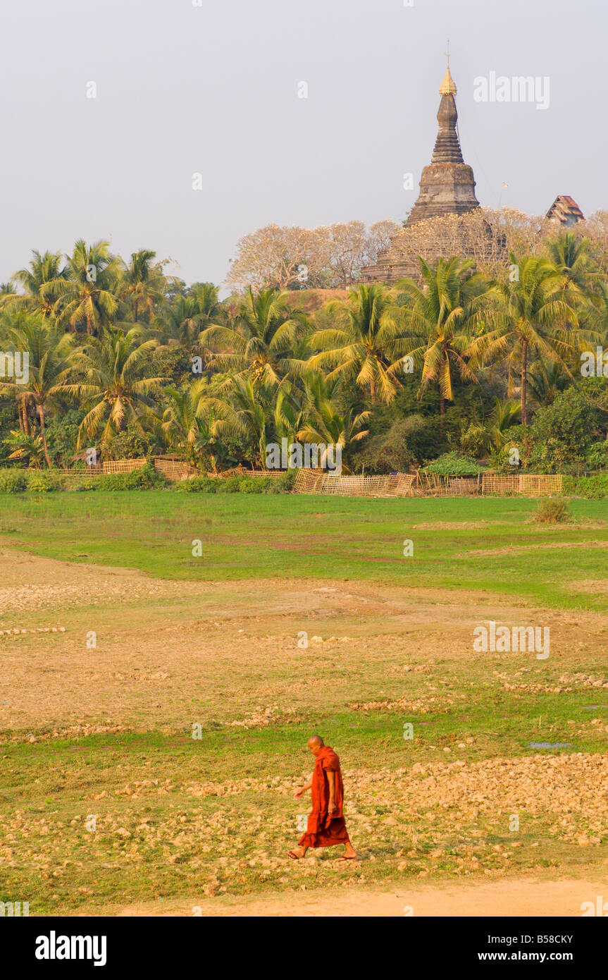 Monk walking past Zina-man-aung paya, Mrauk U, Myanmar (Burma) Stock Photo