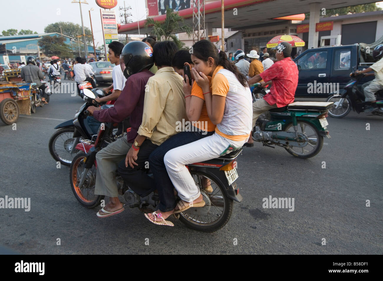 A Cambodian girl is sqeezed between a driver and a passenger of an  overloaded motorbike taxi in the capital Phnom Penh, Tuesday, April 4,  2006. Overloaded motorcycles and cars are a common