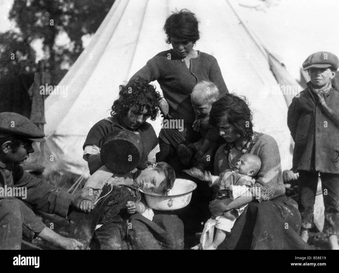 The doctor was asked to go to a Gypsy encampment to get a bee out of a boy's ear and on arriving found that the patient's sister had got his head sideways over a basin and was pouring hot water into the upper ear with a view to working the bee out of the lower! When it was explained to her that we hadn't got a hole running right though our heads, she said: 'well doctor, we always say, don't we, 'in at one ear and out of the other''. October 1937 P007203 Stock Photo