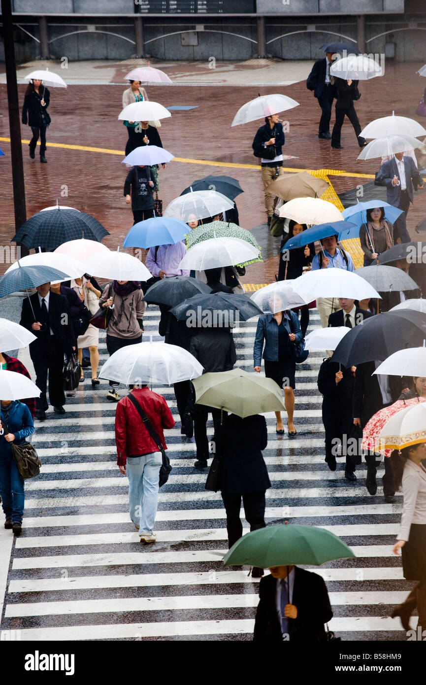 Pedestrians with umbrellas at the main crossing in The Shibuya district ...