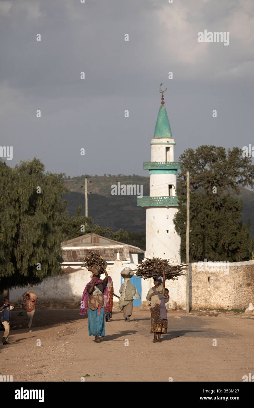 Women carry their wares on their heads, near a mosque in the city of Harar, Ethiopia, Africa Stock Photo