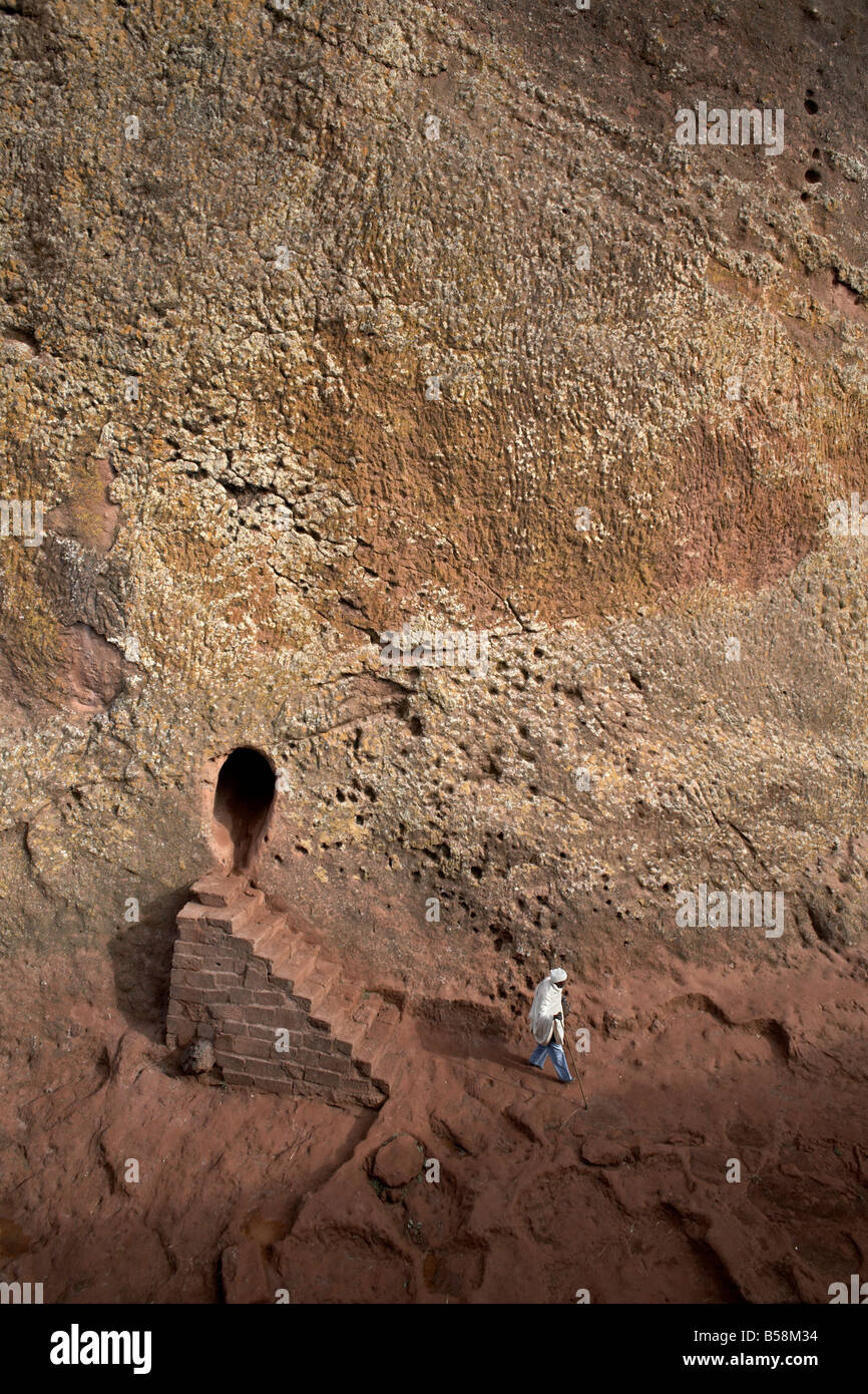 A woman emerges from a tunnel leading to the rock-hewn church of Bet Amanuel, in Lalibela, Ethiopia, Africa Stock Photo