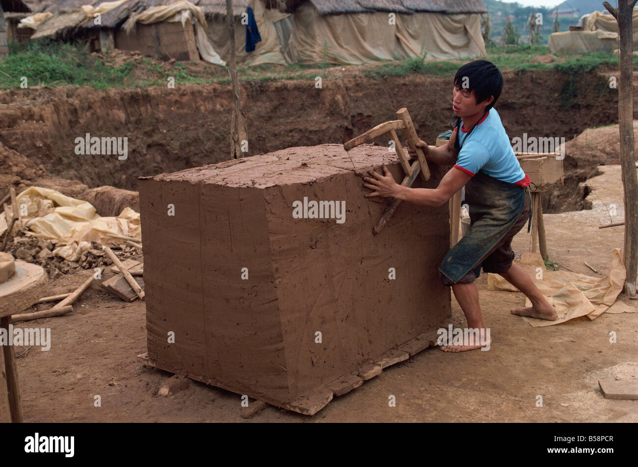 Cutting clay for tiles after it has been mixed south east area Guizhou China Asia Stock Photo