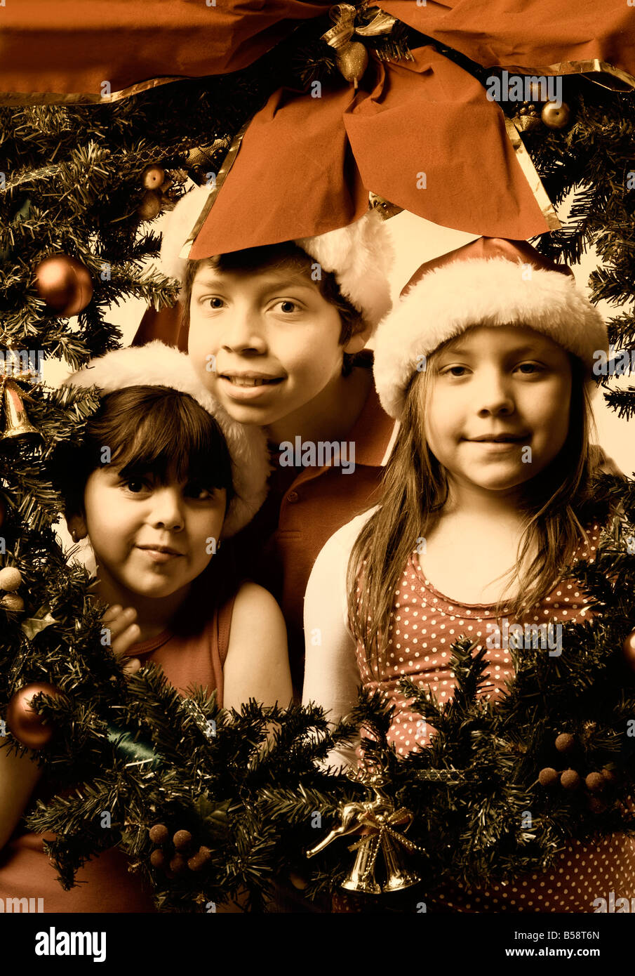 three brothers wearing santa hats inside a green christmas wreath Stock ...
