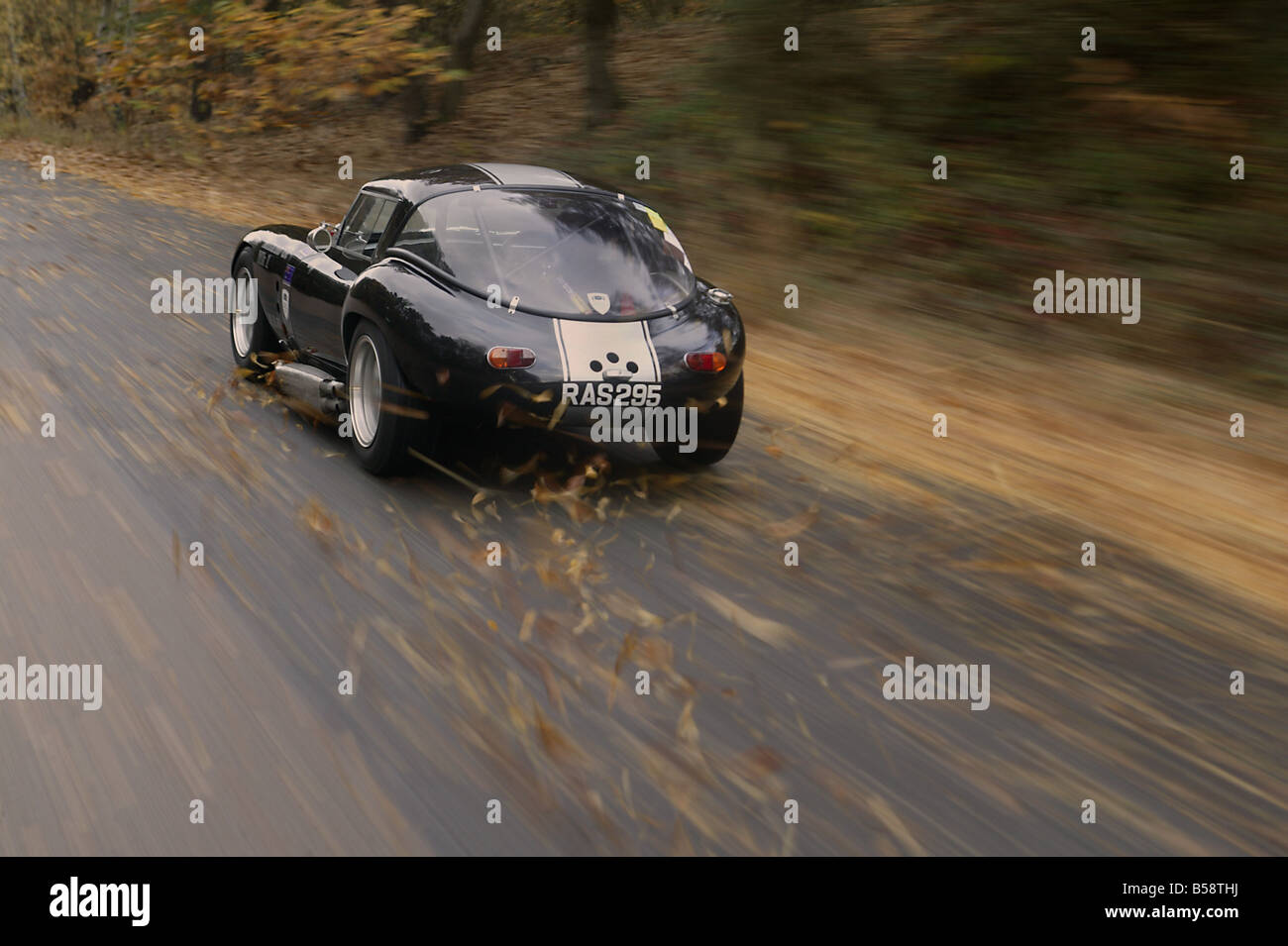 Sportscar speeding along country road in Autunm Fall Stock Photo