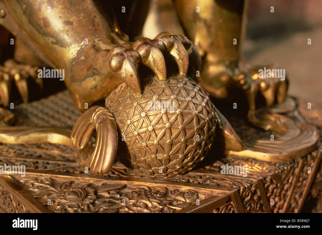 Close-up of the paw of a gilt bronze lion holding a fire ball, symbol of force, in the Forbidden City in Beijing, China Stock Photo