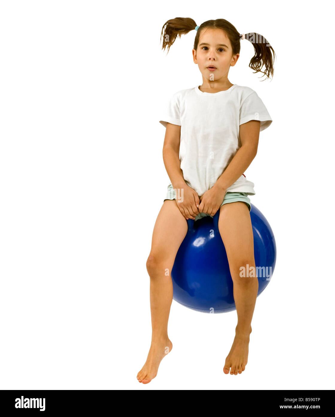 young girl on a blue space hopper isolated on white Stock Photo