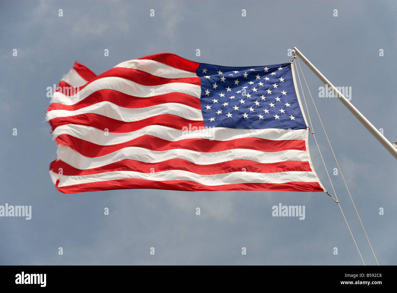 American state flag flying in the wind, with blue sky and clouds in the background Stock Photo