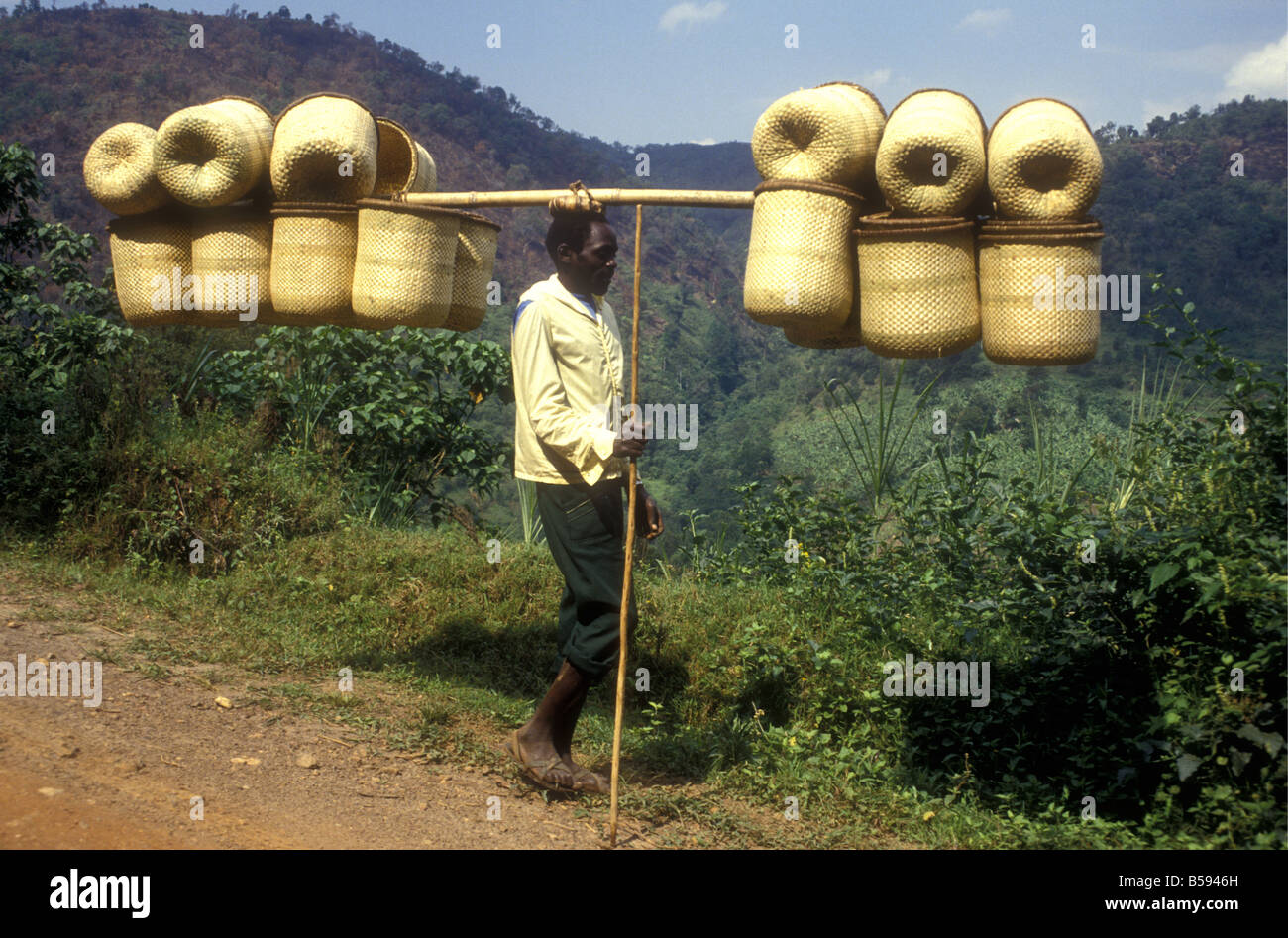 Man carrying baskets to market in South West Uganda Stock Photo