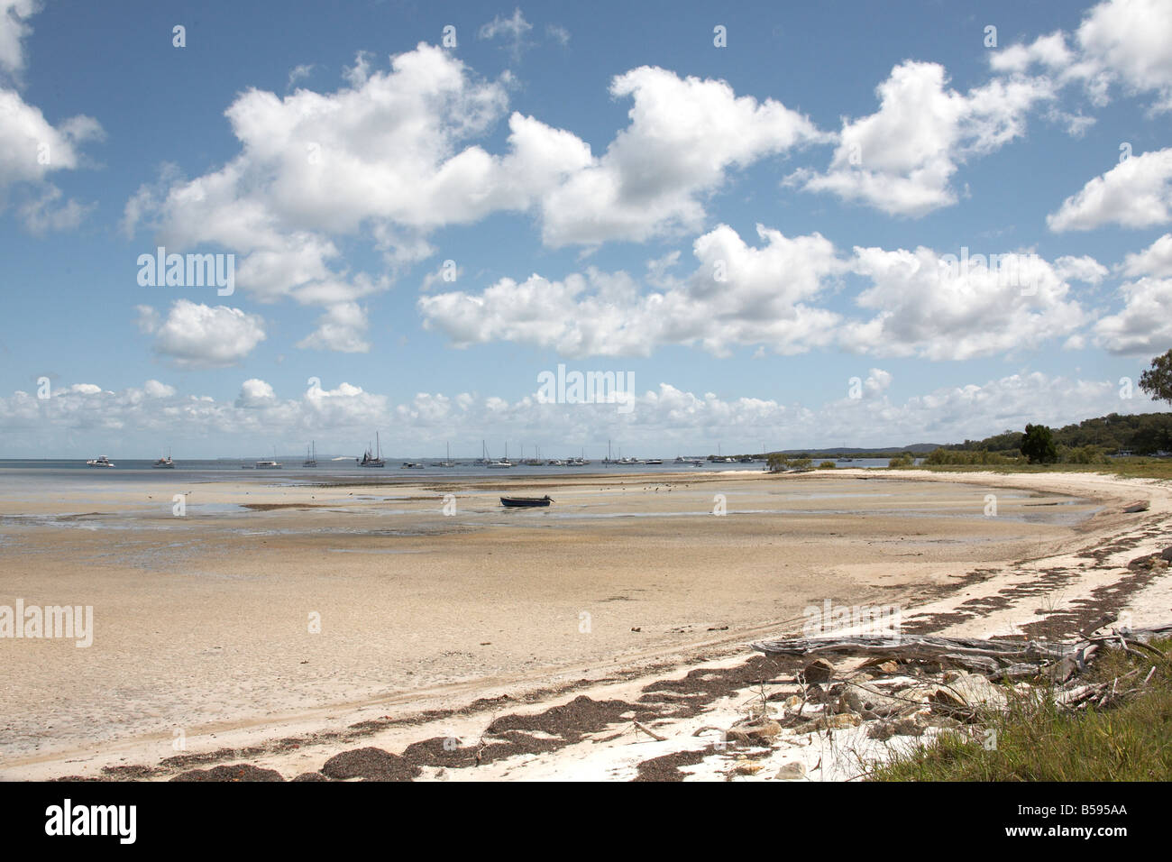 Boats in the sea with beach at low tide near Dunwich on North Stradbrook Island Queensland QLD Australia Stock Photo