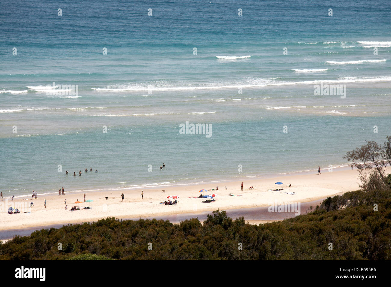 Home beach with people sunbathing and swimming in the sea on North Stradbroke Island Queensland QLD Australia Stock Photo