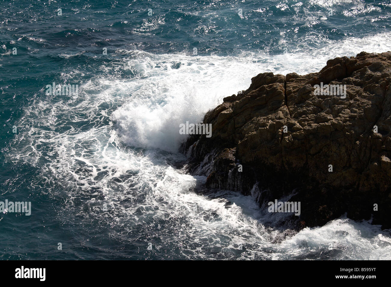 Turbulent sea and foam with wave crashing on rocks from Gorge Walk on North Stradbroke Island Queensland QLD Australia Stock Photo