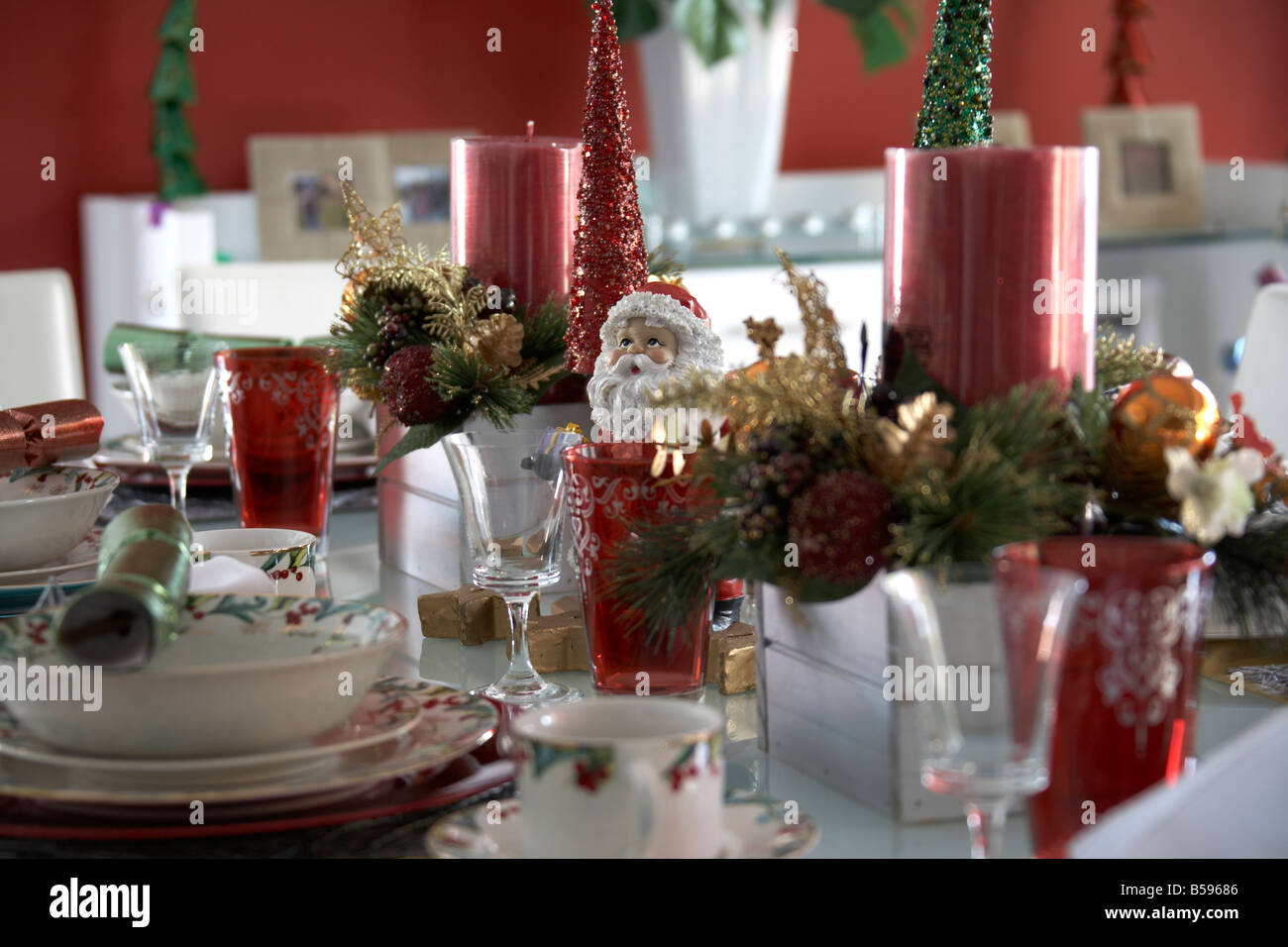 Table laid with Christmas decorations tableware and ornaments in
