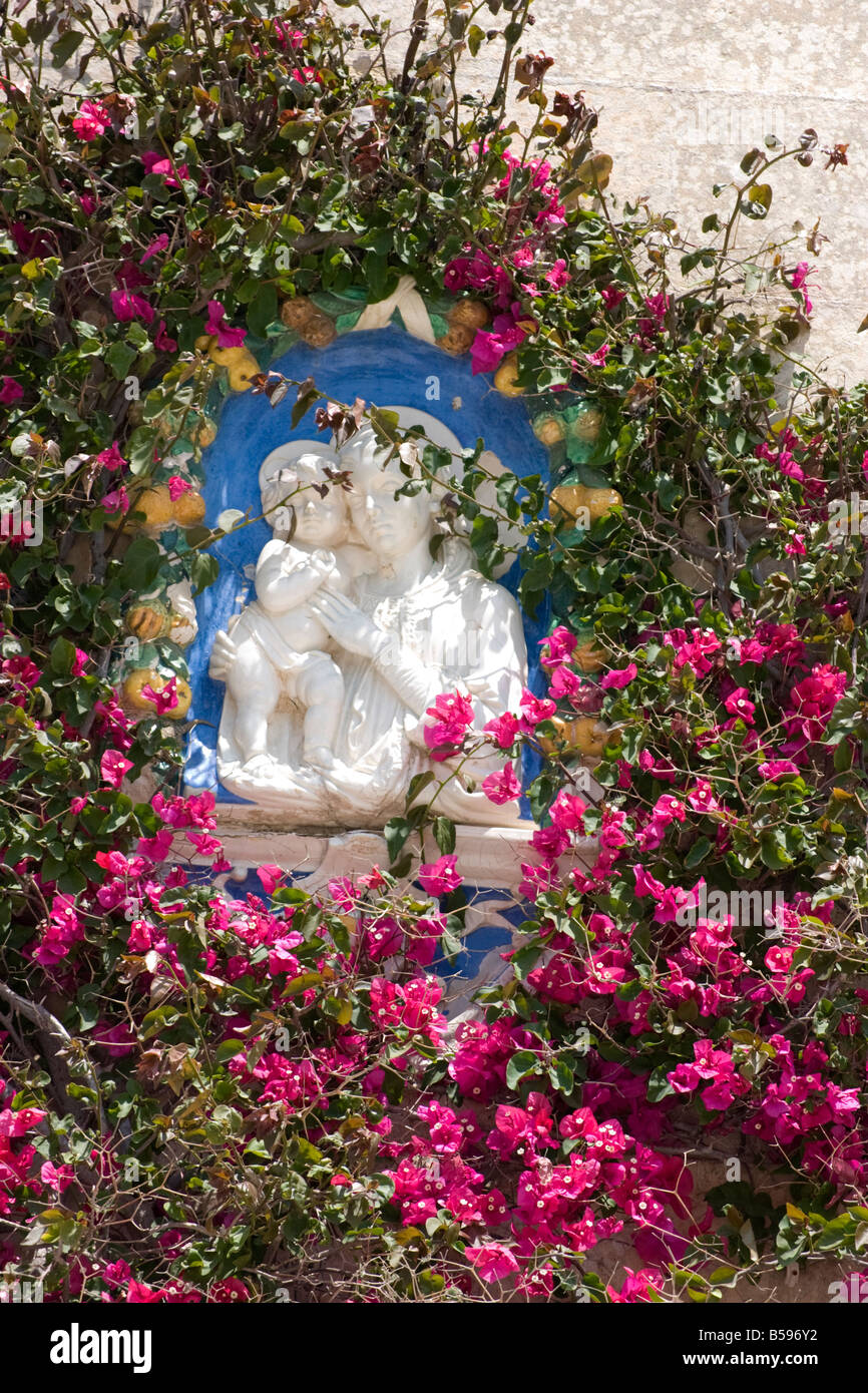 Madonna and child surrounded by bougainvillea flowers on house wall at