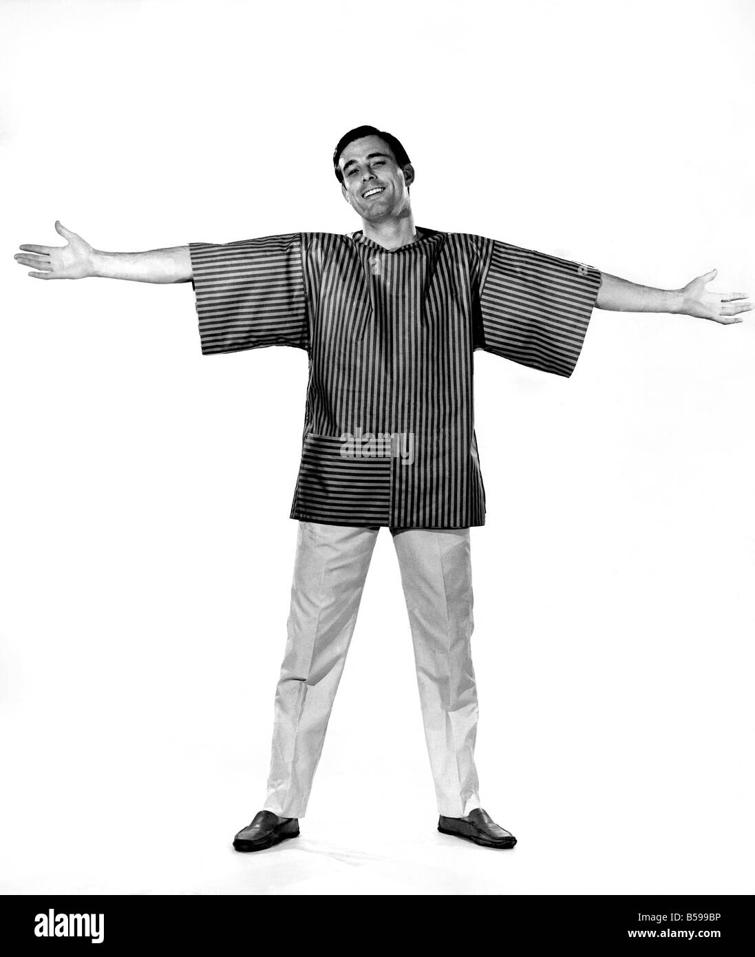 Reveille Fashions 1963: Peter Anthony models a loose fitting striped beach shirt. June 1963 P007623 Stock Photo