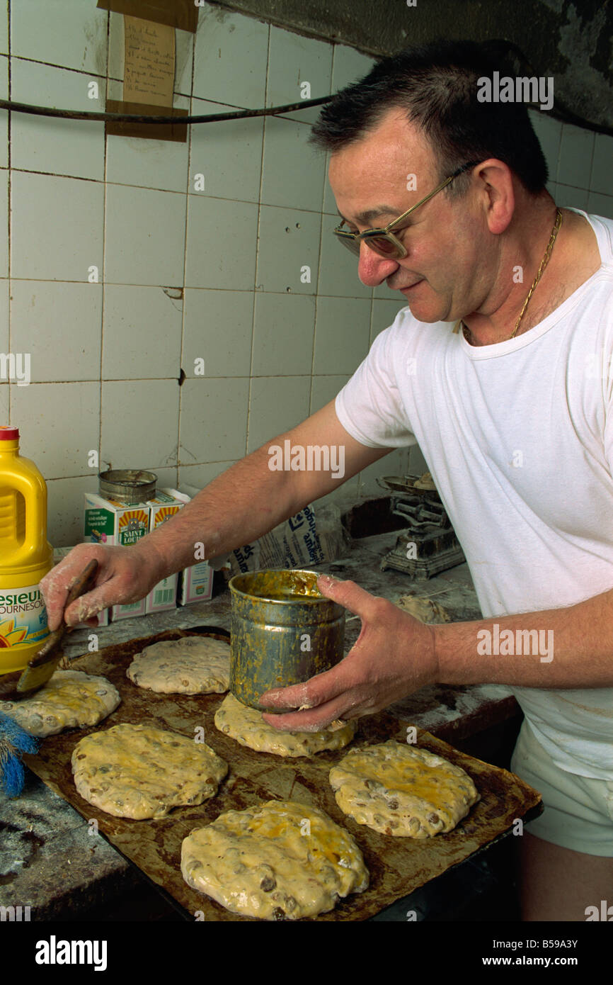 Man making Pain des Mortes, Boulangerie Faby, Bonifacio, Corsica, France, Europe Stock Photo