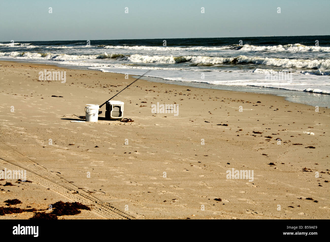 Fishing pole, cooler, sandals and bait bucket on a beach in Ponte Vedra Beach, Florida Stock Photo