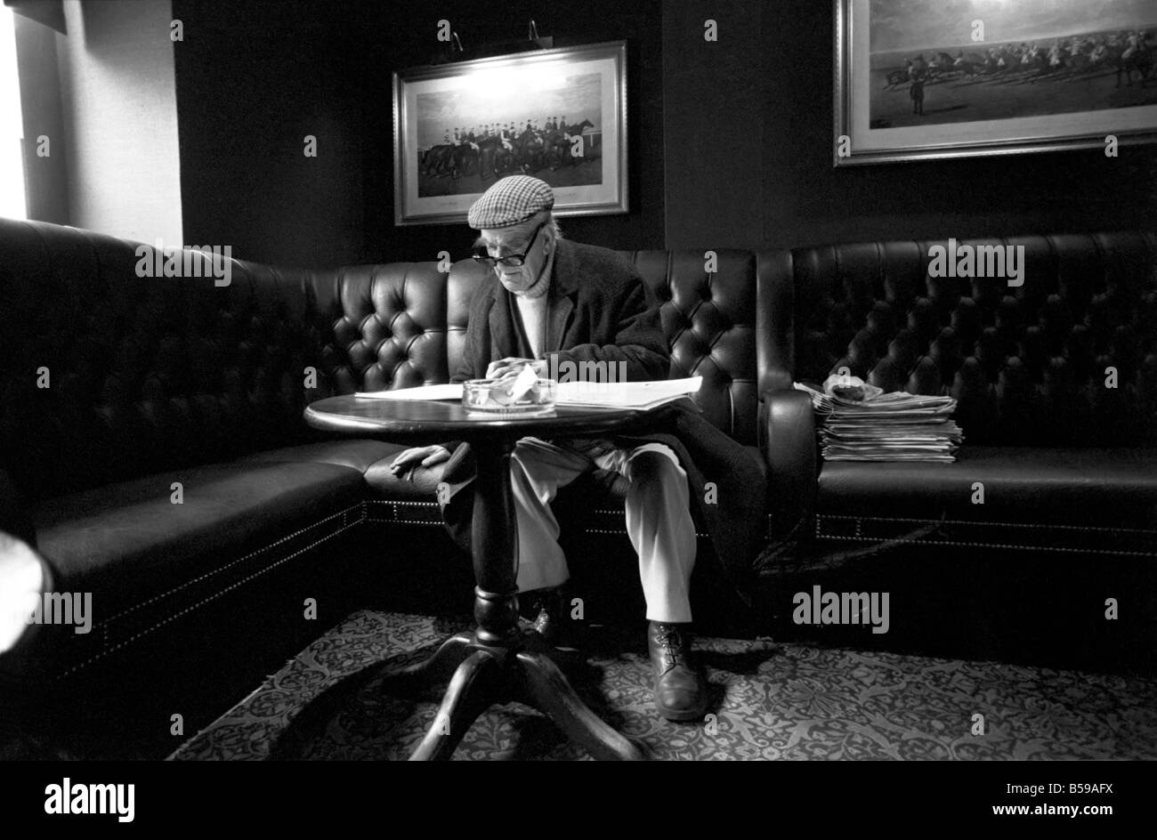 Pensioner: Elderly man filling his pools coupon whilst enjoying a cigarette and a pint in his local pub. PM 81-01800a Stock Photo