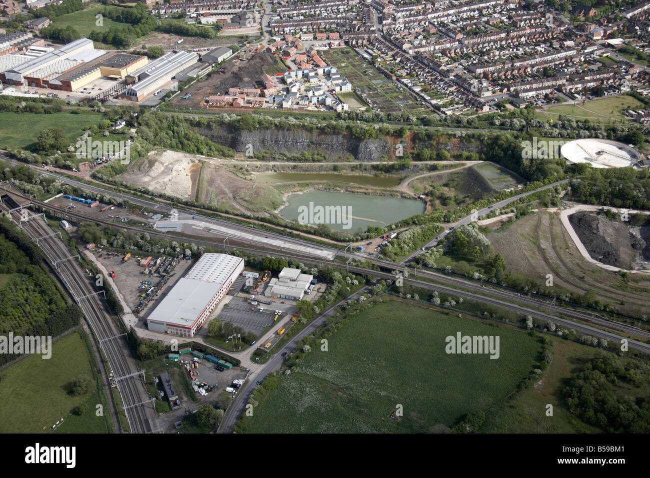 Aerial view south east of industrial estate sand pit allotments suburban houses railway line country fields Rugby Warwickshire Stock Photo