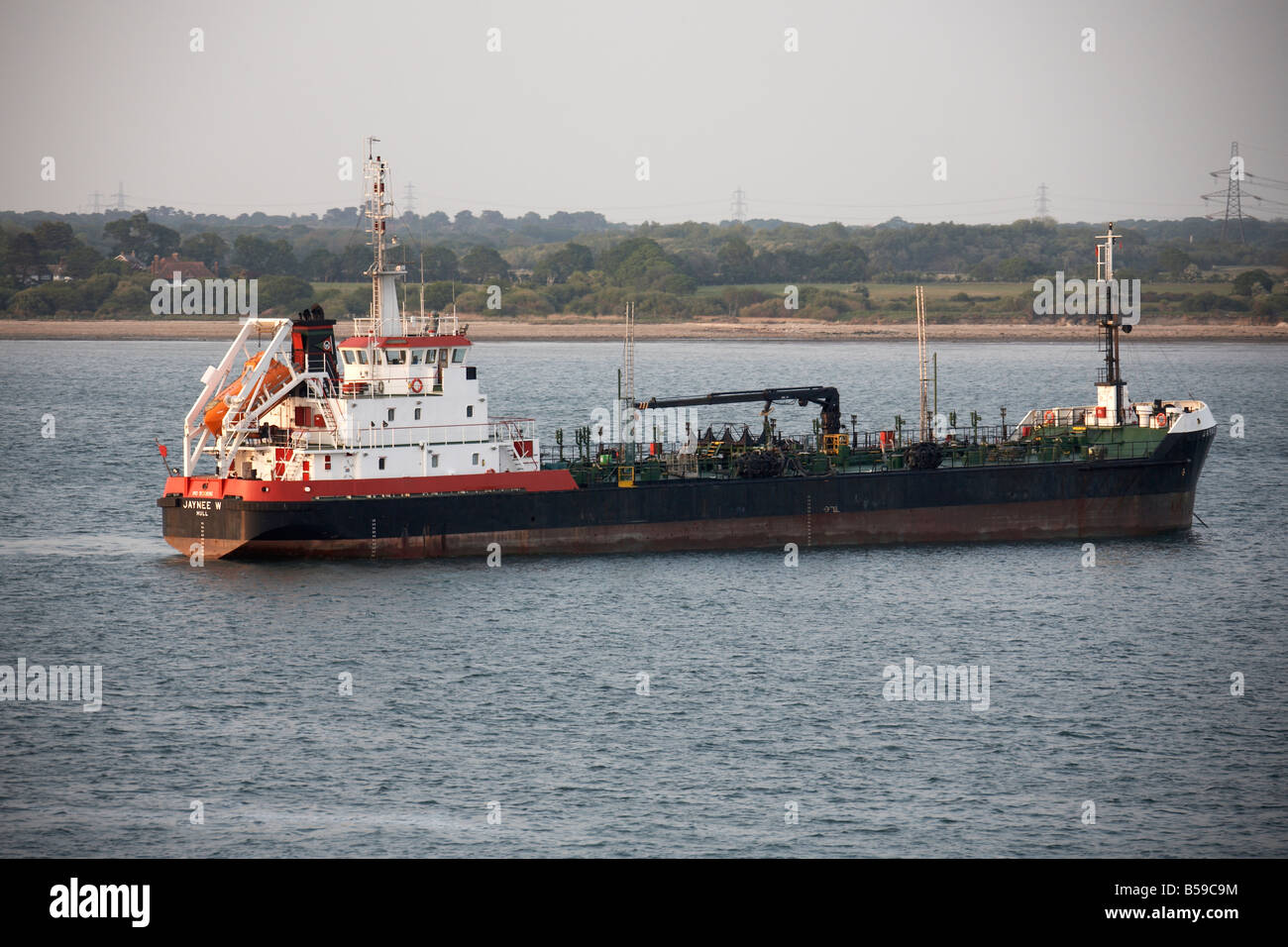 Jaynee merchant shipping vessel ship sailing on Southampton Water in evening light England UK Stock Photo
