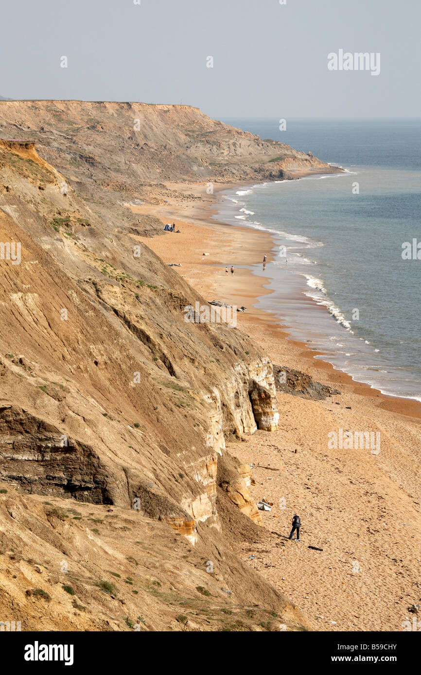 People sunbathing and swimming on Brightstone Bay sea beach with south coast cliffs Isle of