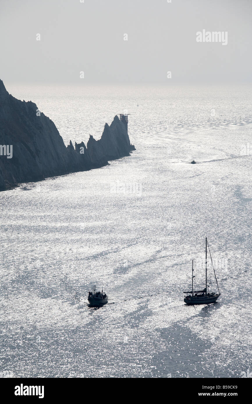 The Needles rocks with sea cliffs and sailing boat yacht in evening light silhouette Isle of Wight England UK 200705 QE sailing Stock Photo