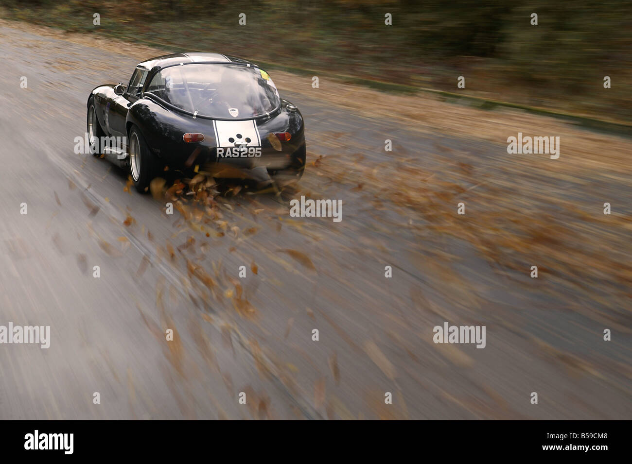 Sports car speeding down country road in Autunm Fall Stock Photo