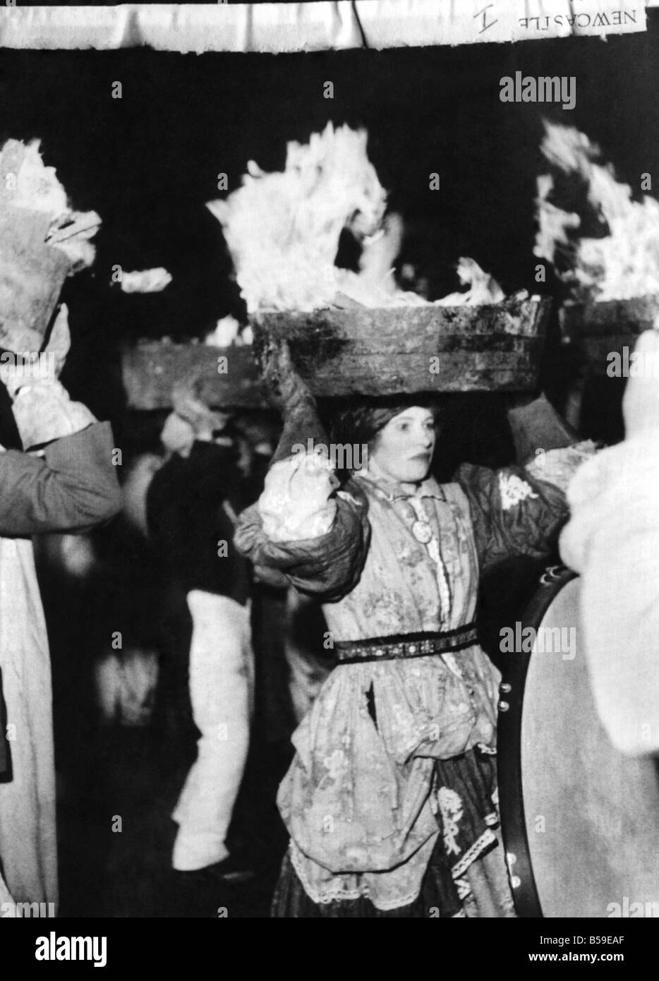 Women balancing barrels of burning tar upon their heads during the Pagan New year ceremony in the town of Allendale in Northumberland;January 1956 ;P005035 Stock Photo