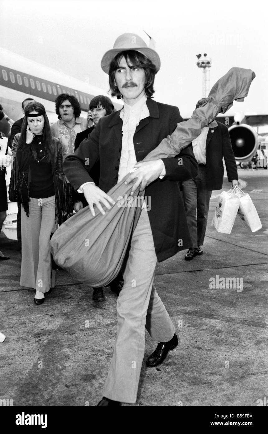 Beatles guitarist Harrison complete with sitar at Heathrow. June