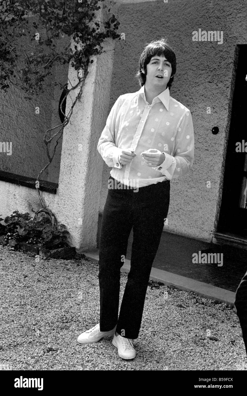 Beatles singer Paul McCartney relaxing in the grounds of his father's home in Gayton in the Wirral, Cheshire, wearing a pink polka-dot shirt and black slacks - and white plimsolls. ;July 1968 ;Y07136-002 Stock Photo