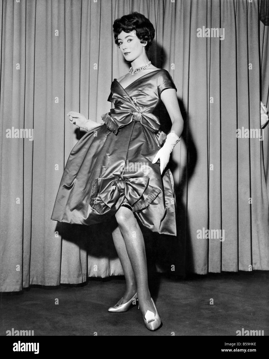 Pat O'Reilly modeling a short evening dress called 'Amour' in begonia red pure silk satin. June 1958 P008015 Stock Photo