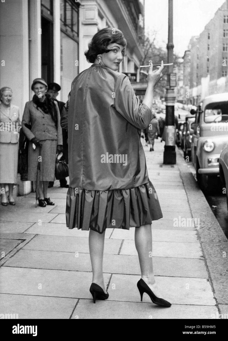 Guess What: It's a raincoat - no kidding! Styled on the Charleston dresses  of the 1920s it was in the spring rainwear collection of Paul Blanche shown  in London. October 1957 P008025