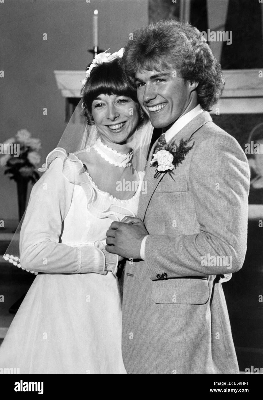 Before the altar for a Coronation Street wedding are actor Christopher Quinten and actress Helen Worth. They play Brian Tilsley Stock Photo