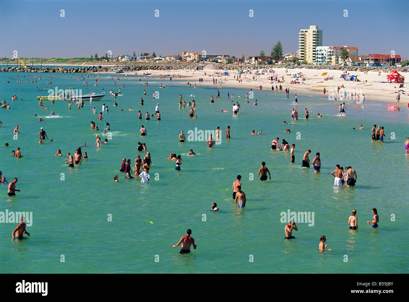 Groups of people in the sea and on the beach at Glenelg, where first South Australian colonists landed, Australia Stock Photo