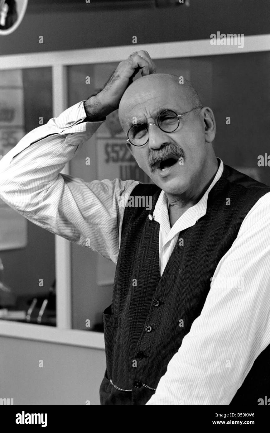 Warren Mitchell scratches his head trying to decide which team he wants to win the cup out of West Ham or Fulham. April 1975 Stock Photo