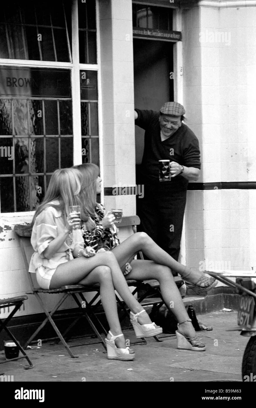 Two women stop at a pub to have a pint of beer while shopping on Kings Road in Chelsea, London. ;April 1975 ;75-2156-004 Stock Photo