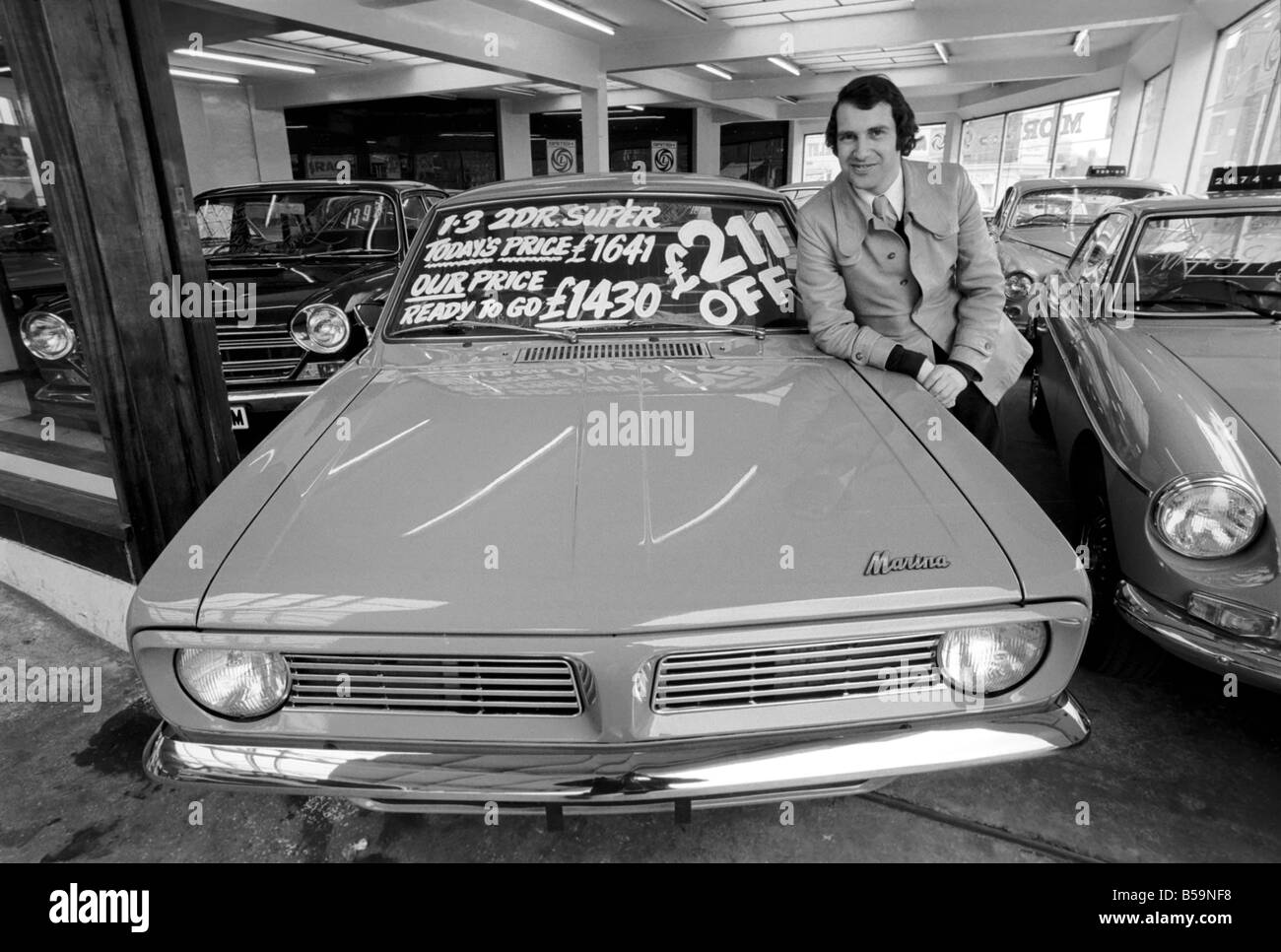 Secondhand car salesman Mr. John Leek of Birmingham All Electric Garage seen here with his offer of the week, a British Leyland Stock Photo