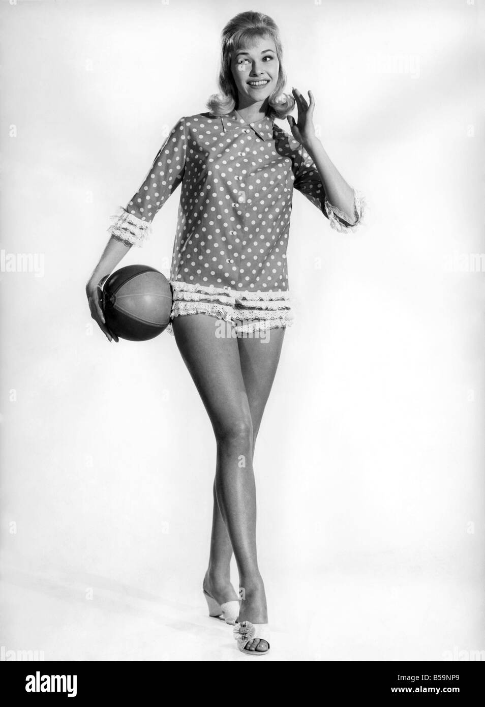 Model Jo Waring wearing a polka dot patterned top and holding a beach ...