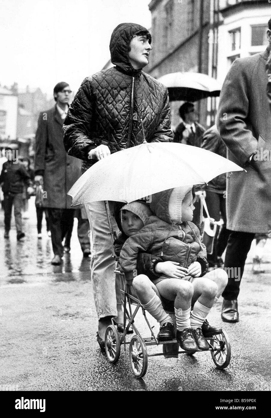Durham Miners Gala The heavens may have opened but these two young gala spectators are all right under the umbrella given up by Stock Photo