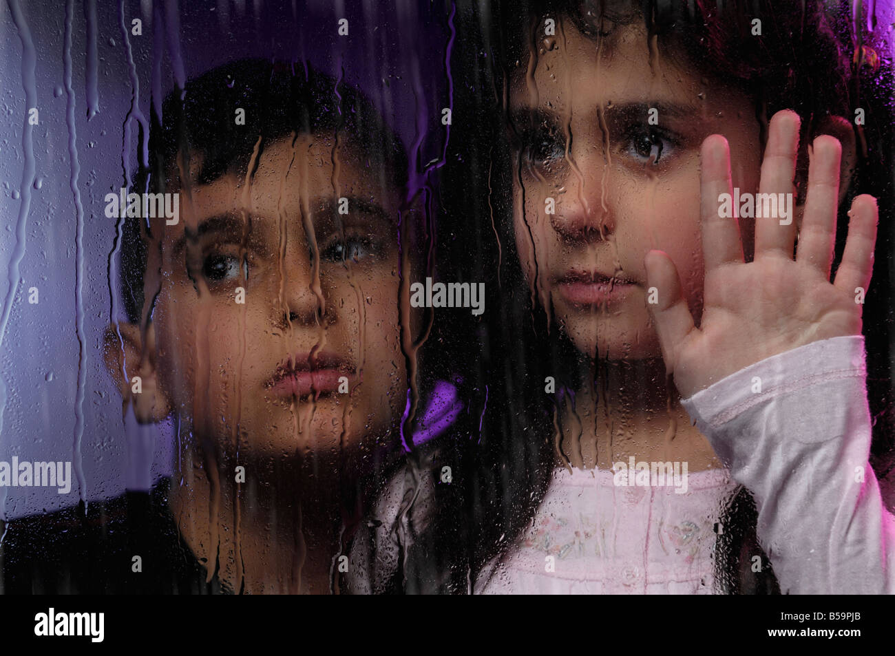 Two children behind window Stock Photo