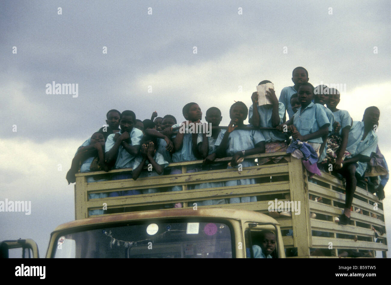 Group of happy excited school children in school uniform on a crowded lorry truck for a school outing trip Uganda Stock Photo