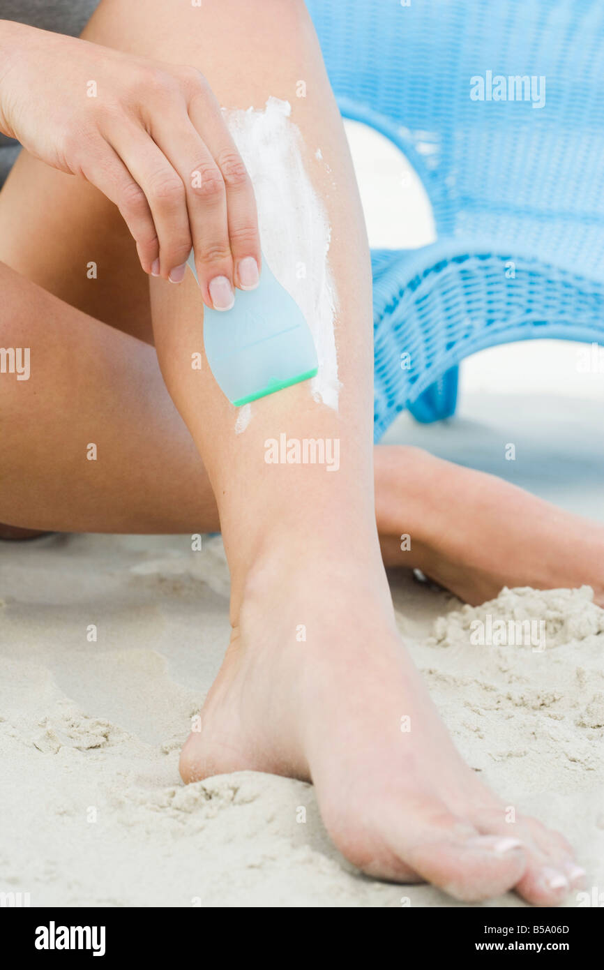 woman shaving legs on beach Stock Photo - Alamy