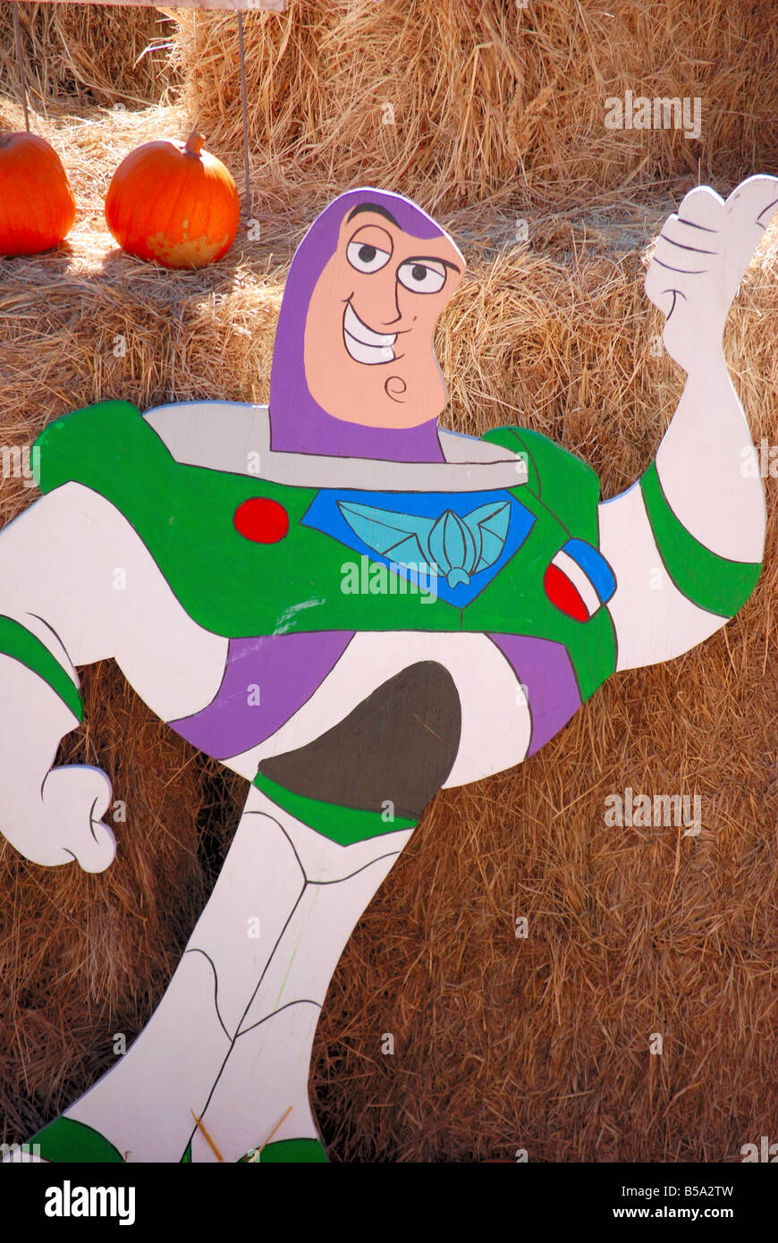 Buzz Lightyear wooden sign pointing to the entrance of a children's maze made out of hay bales Stock Photo