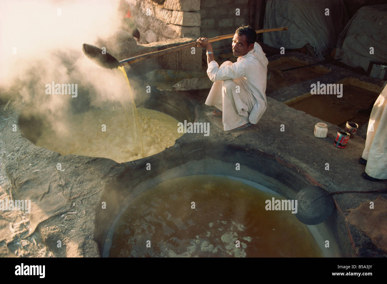 Boiling off water from cane juice to make jaggery sugar after sugar