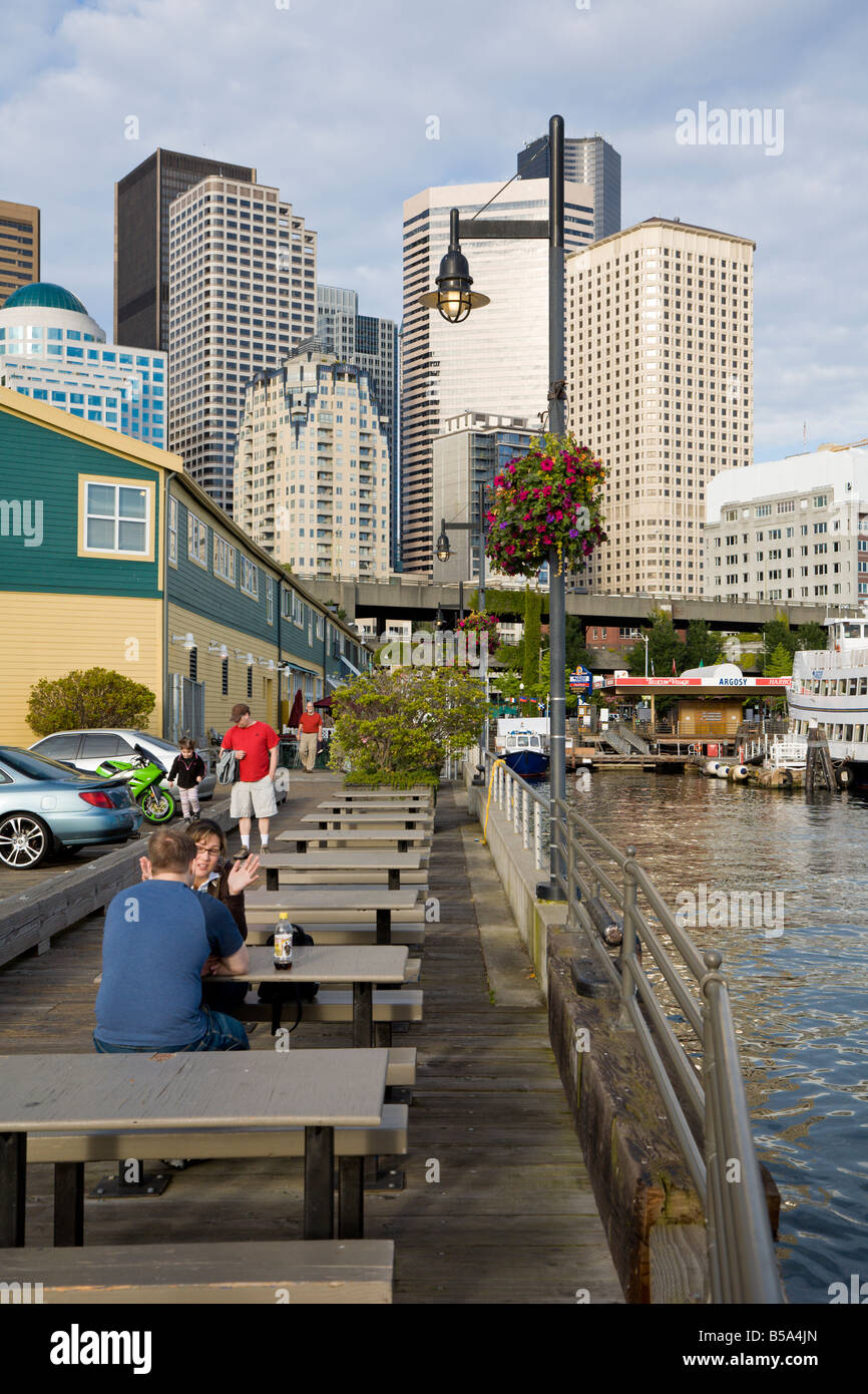 Couple sits at dockside table near Pier 55 on the Seattle waterfront Stock Photo